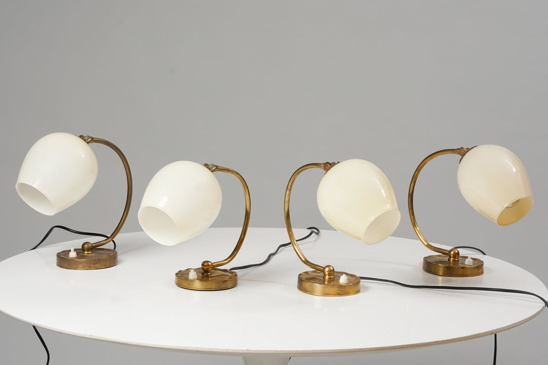 Brass framed lamp with opal glass dome. The lamp has a white switch on the base.