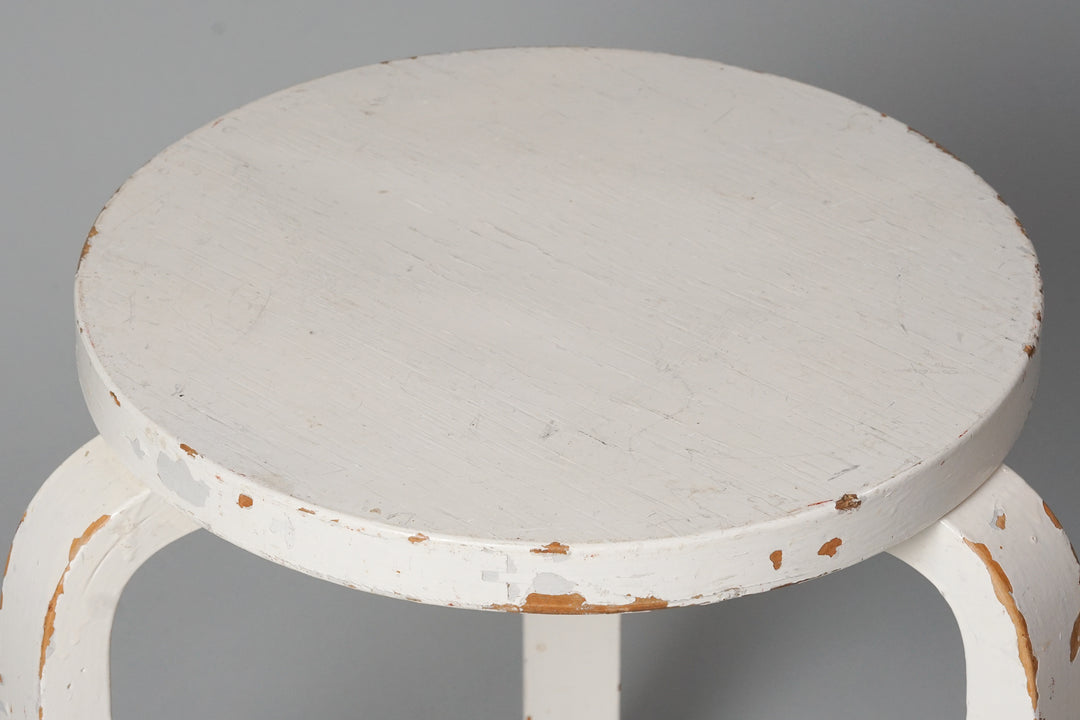 Three legged stool made of birch with a round seat. The stool is painted white.