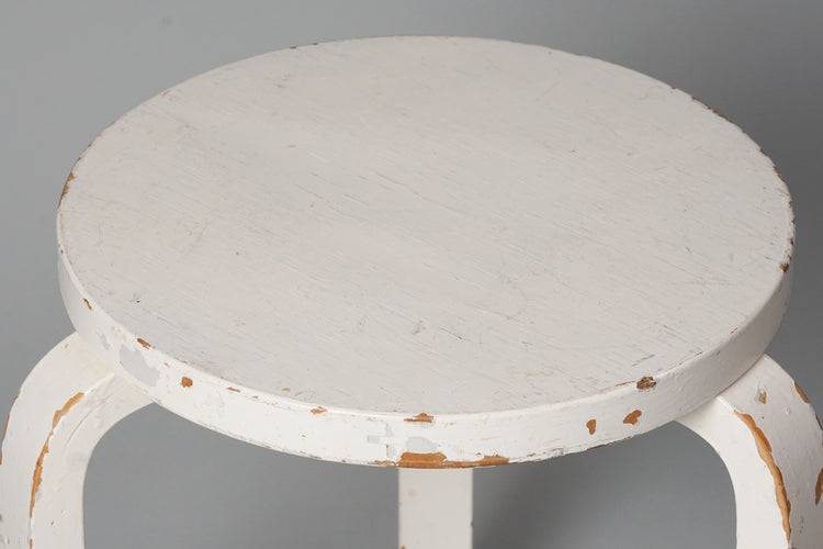 Three legged stool made of birch with a round seat. The stool is painted white.