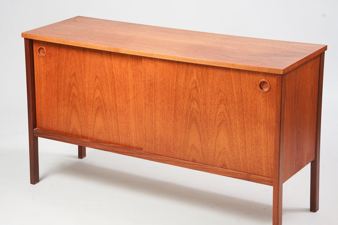 Sideboard made of teak with two sliding doors, shelves and a drawer.