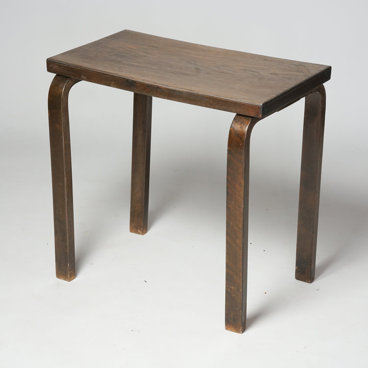 A dark side table with stained birch frame and oak veneer surface. The table has four legs and is rectangle shape.