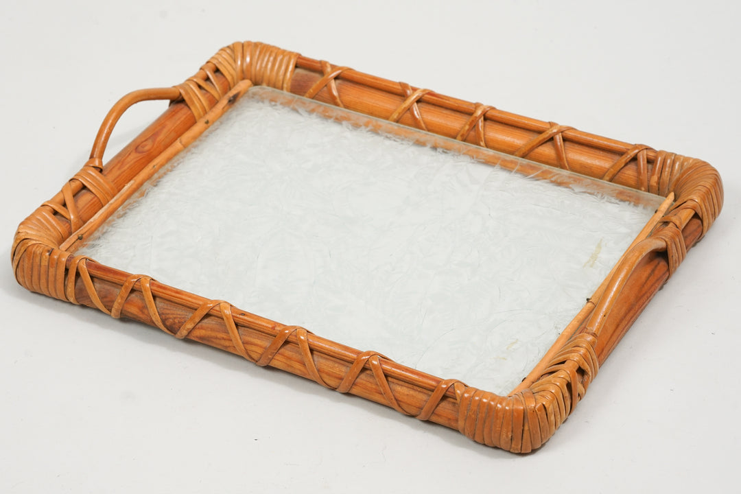A rattan tray with two handles and a glass top.