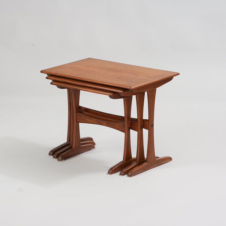 Three similar teak tables in different sizes. The tables fit under each other.