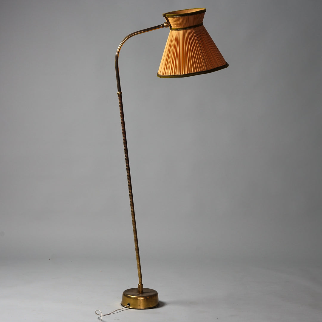 Lattiavalaisin, jossa messinkirunko. Varjostin poltetun oranssia laskostettua kangasta, jossa tumman virheät samettireunukset.