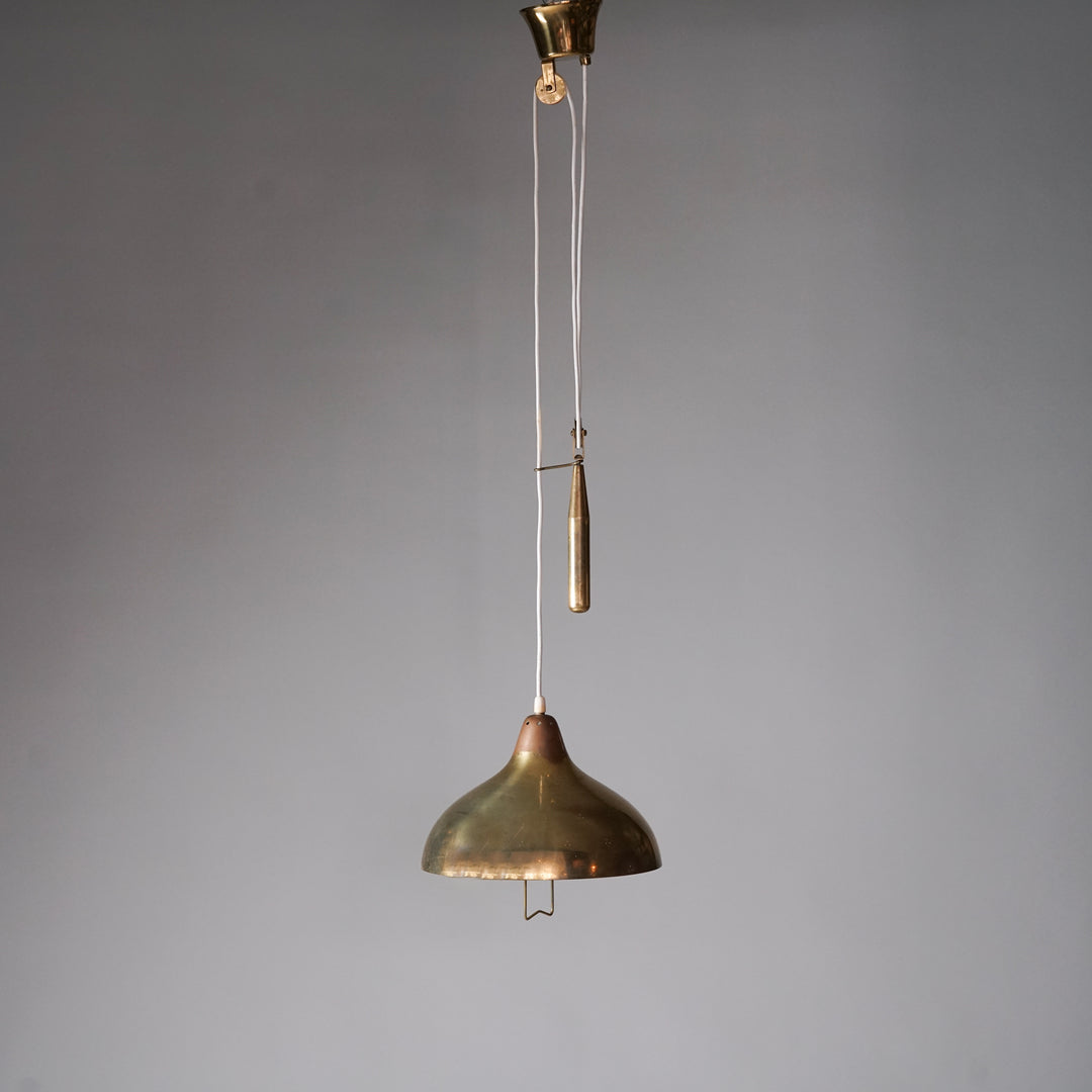 Brass ceiling light with counterweight mechanism. The shade features small three-hole clusters that reflect light and has a handle in the middle.