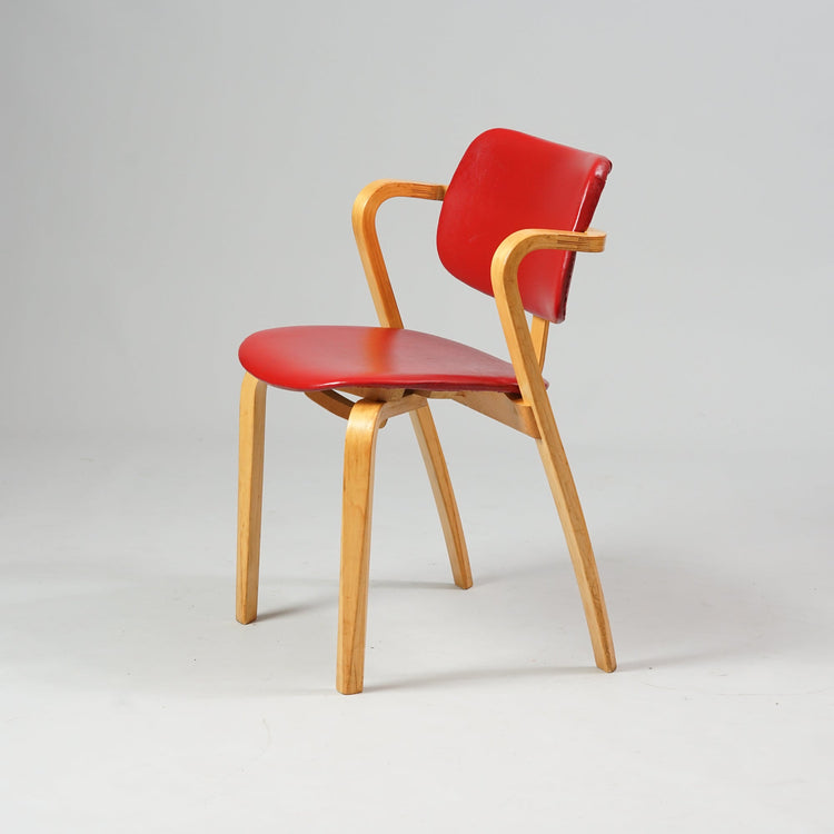 Chair with birch frame and seat made of red faux leather.