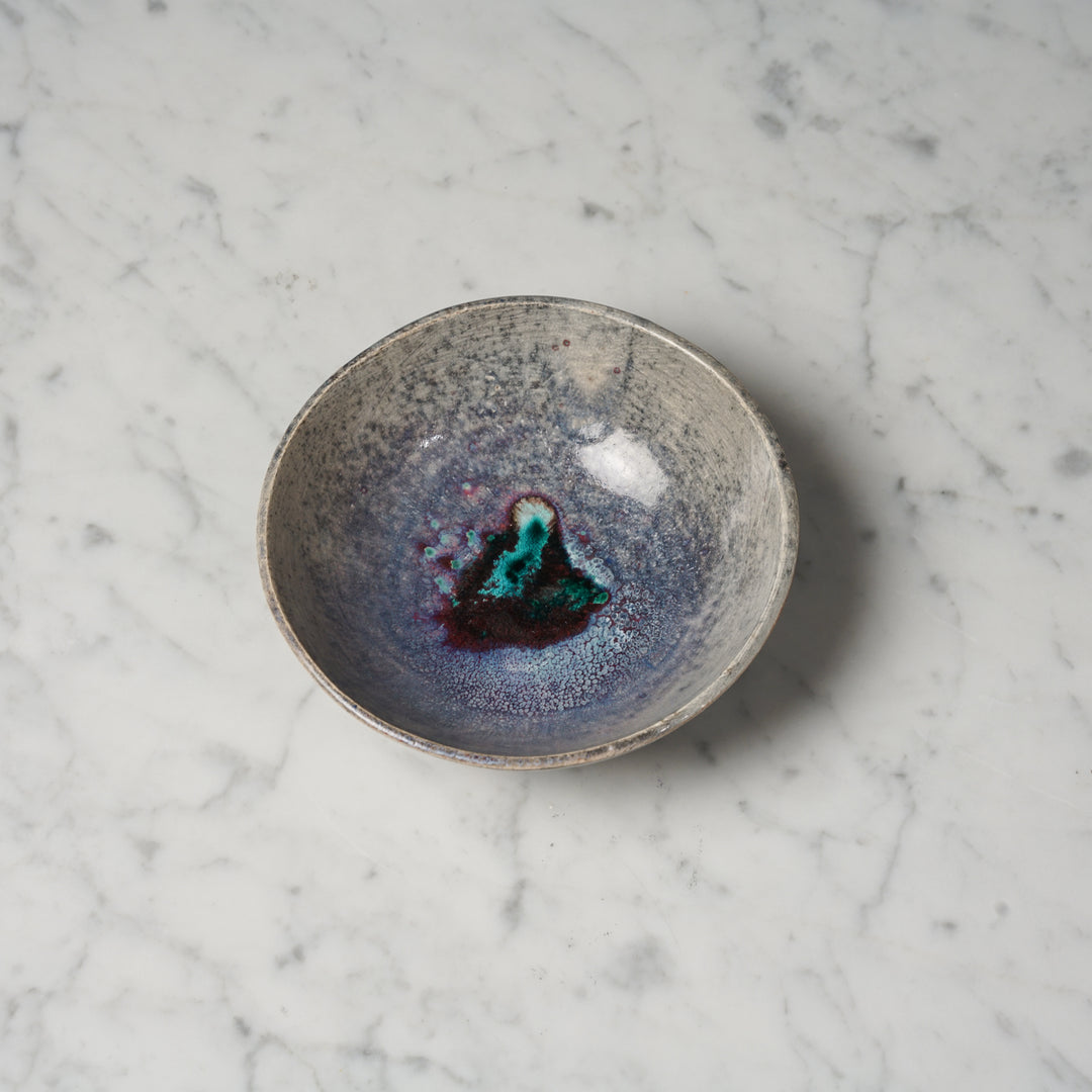 Ceramic light brown bowl, that has very unique color. Inside the bowl is purple and in the middle is a darker spot with green and turquoise.