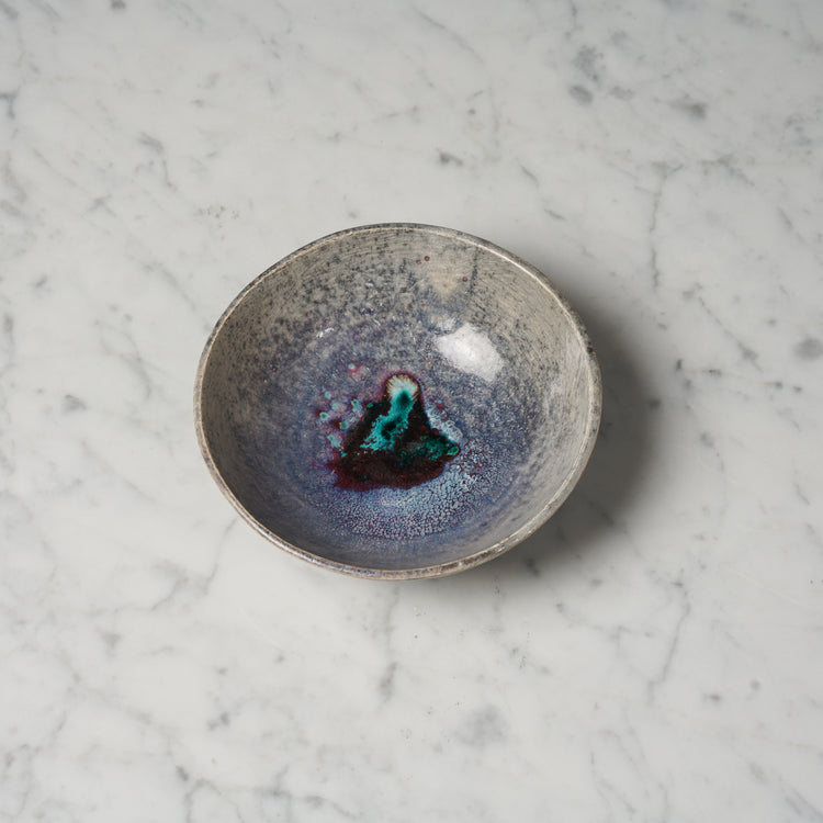 Ceramic light brown bowl, that has very unique color. Inside the bowl is purple and in the middle is a darker spot with green and turquoise.