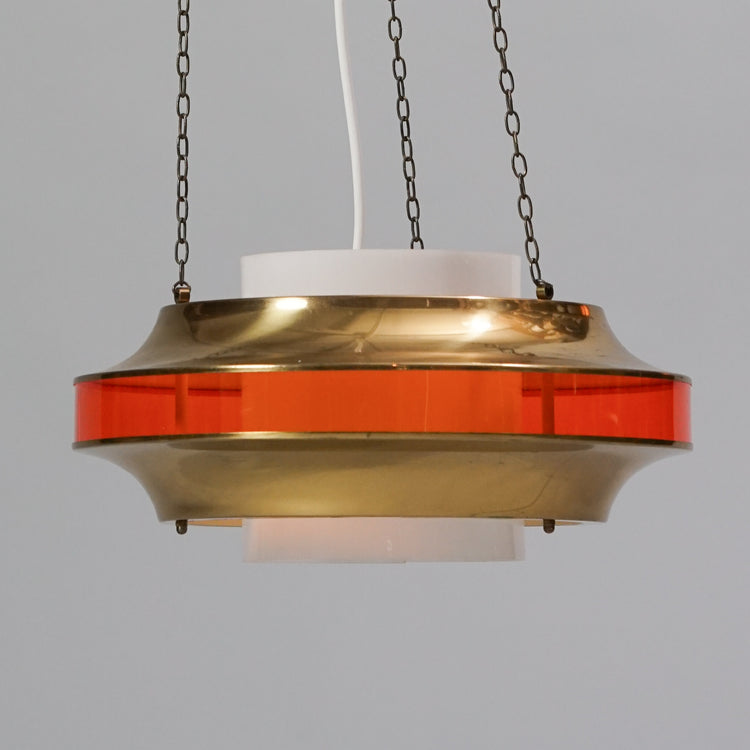 Brass lamp with a orange plastic see-through part in the middle.