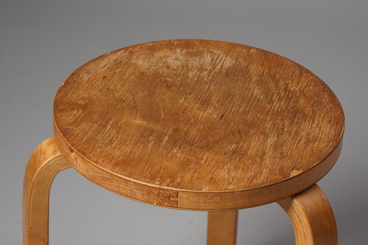 A stool with a circle seat and three legs made of birch.