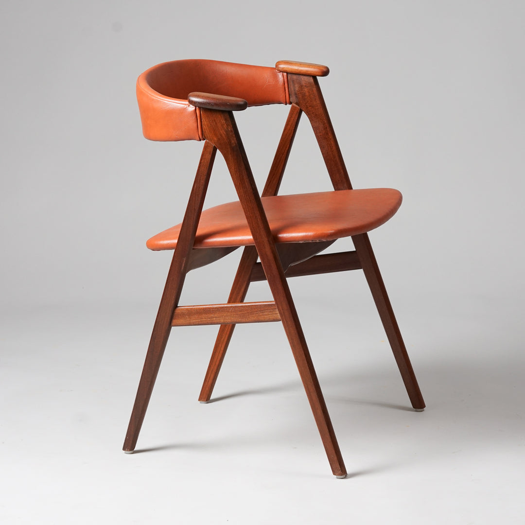 Two identical chairs, sold separately. The chairs have a crescent-shaped backrest in orange-brown faux leather, as well as the seat. 