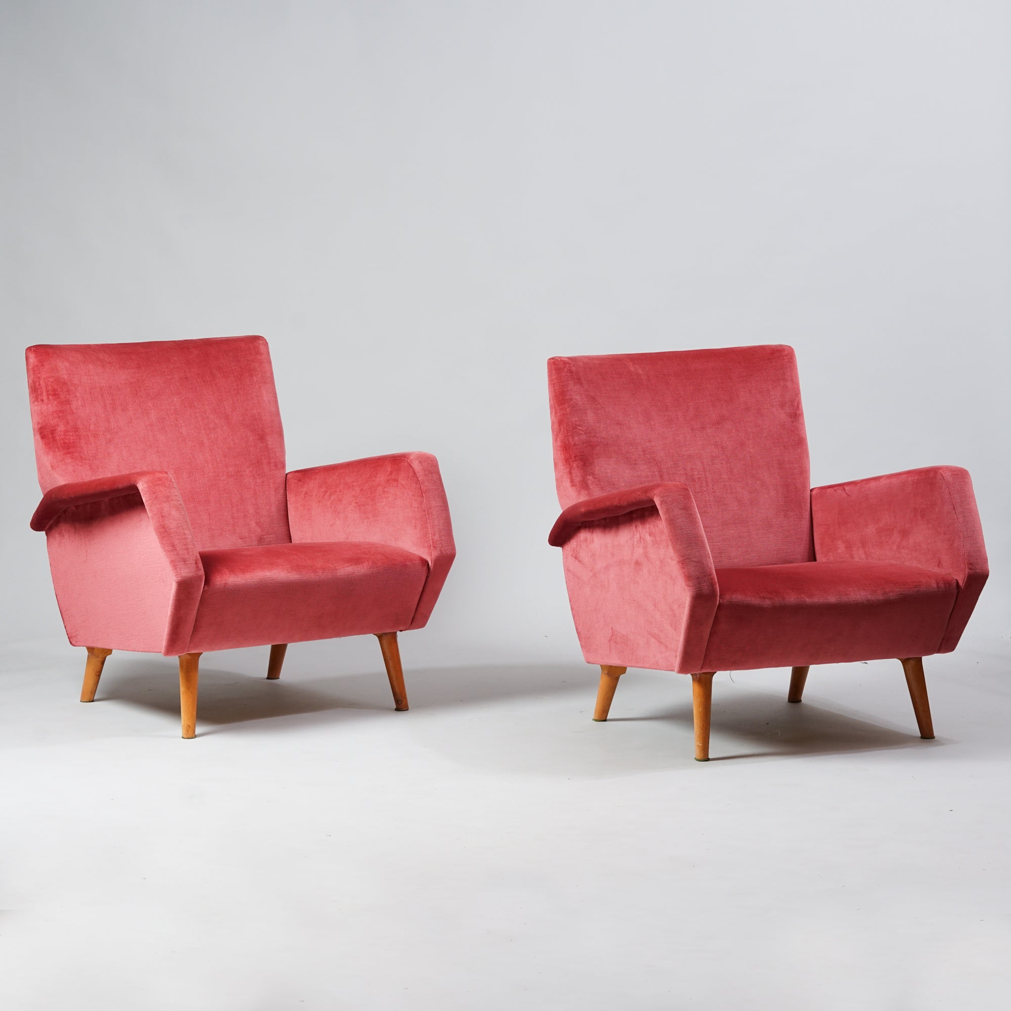 Kaksi samanlaista nojatuolia, joissa tammirunko. Nojatuolit ovat päällystetty vaaleanpunaisella plyysikankaalla. 