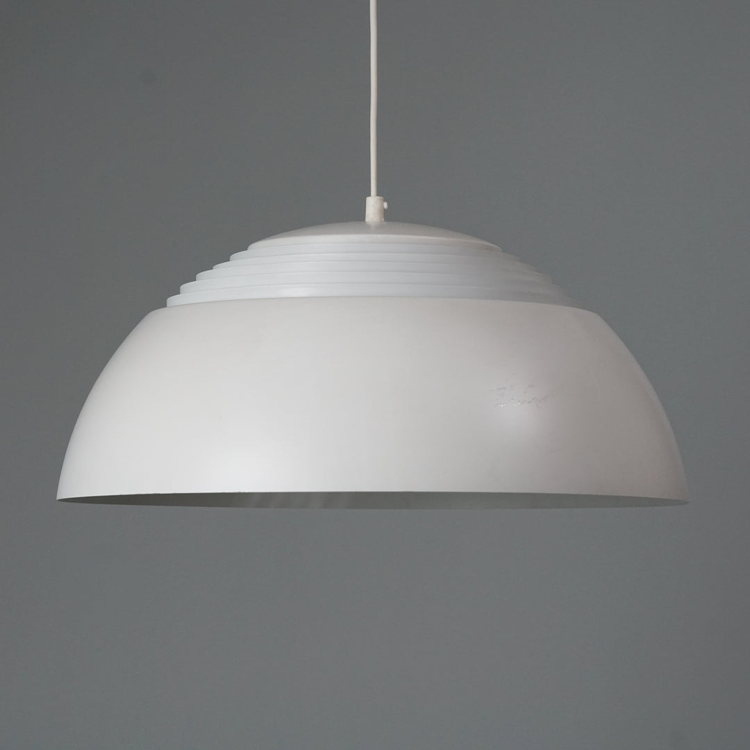 Ceiling light. White painted metal. The upper part of the lampshade has a grille that reflects the light out.