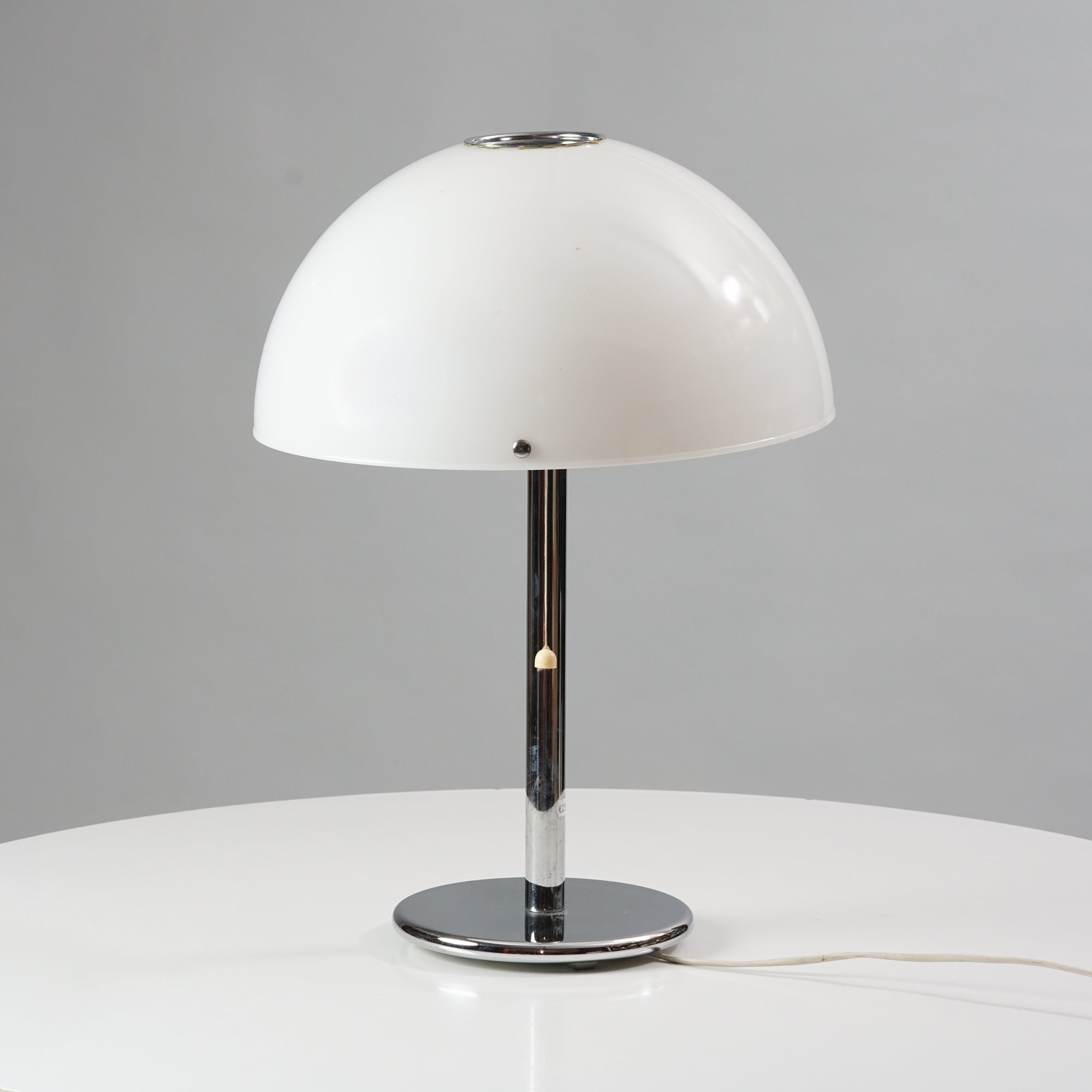 Lamp's plastic shade is white, while the frame is chromed metal.