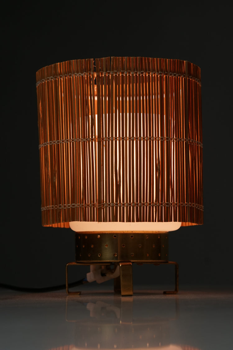 A lamp made of cloudy glass with brass base and shade made of wood.