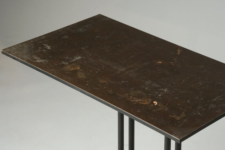 A dark side table made completely from metal.