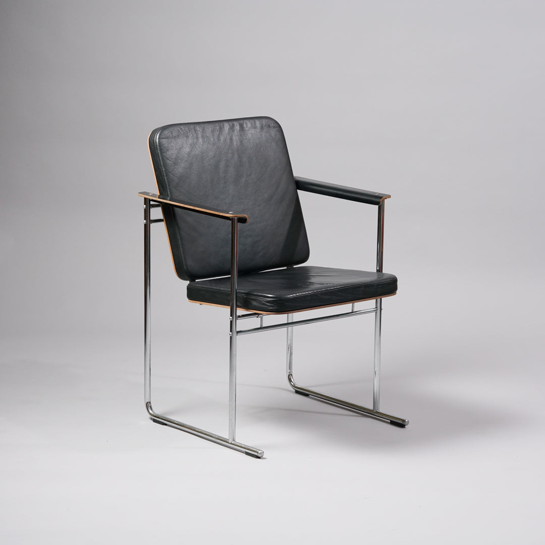 Kaksi samanlaista tuolia, joissa runko on kromattua metallia, käsinojat koivuvaneria ja istuinosat nahkaa,