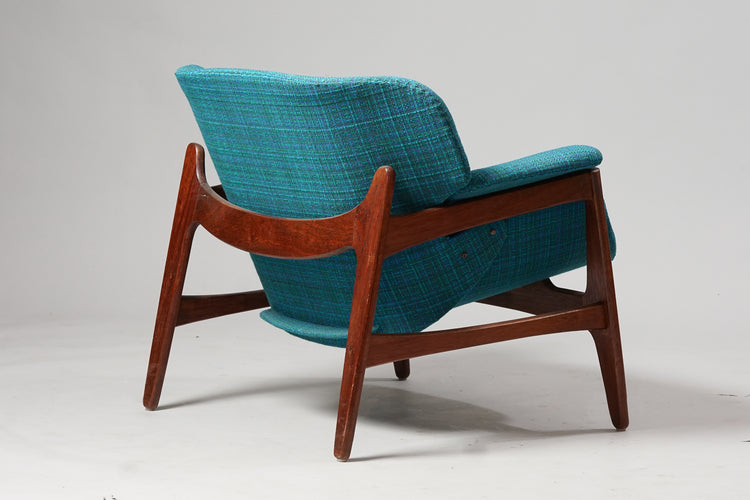 Wide armchair with teak frame and seat upholstered in blue woolen cloth. 