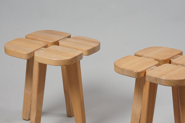 Two identical wooden stools. The stools are shaped like a four-leaf clover.