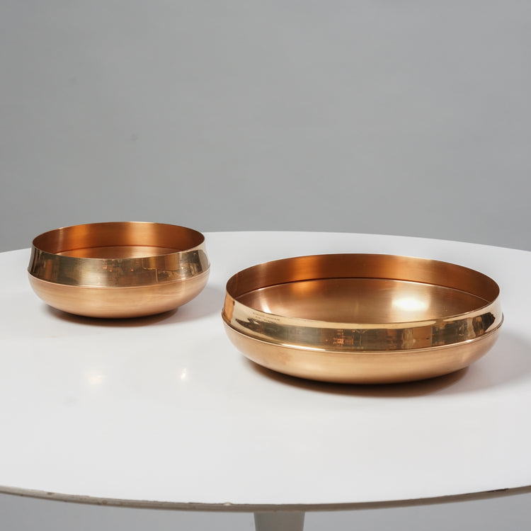 Two bronze bowls. Bigger bowl is wider but both bowl are the same depth.