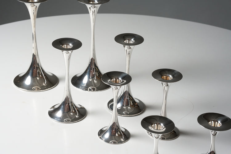 Eight candle holders. They are thin in the middle but widen out at the bottom and top.