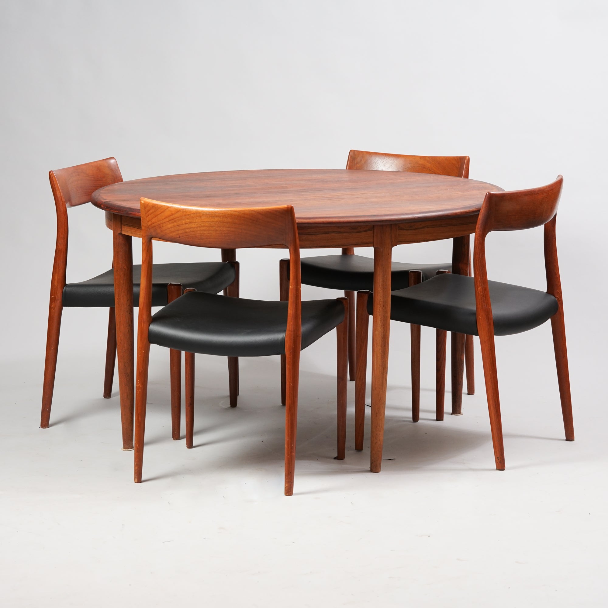 Round extendable table, dark in color. Made from Jacaranda tree.