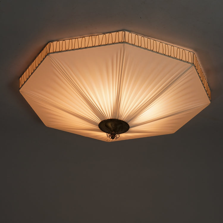 White octagon plafond, with pleated plastic shade. The middle and sides of the lamp have brass detailing.