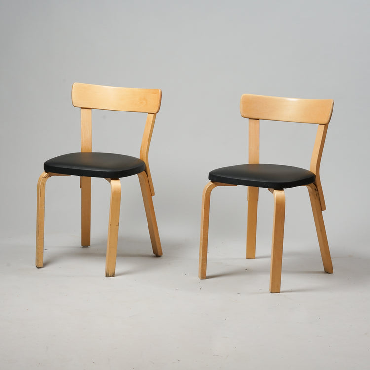 A chair made of birch with a backrest and a seat made of black leather.