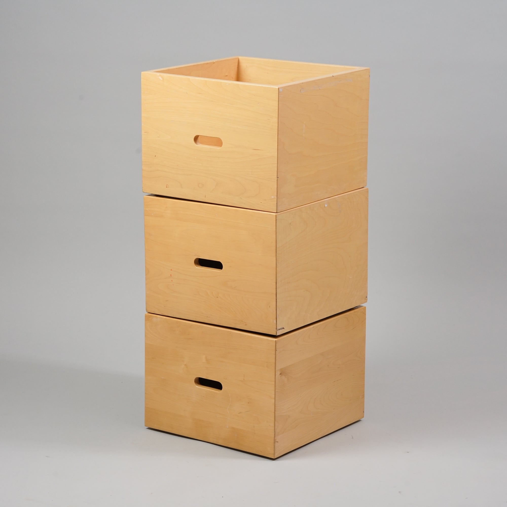 Koivusta tehty neliön muotoinen laatikko, jossa kolo kahvana. Laatikon pohjassa on rullat.