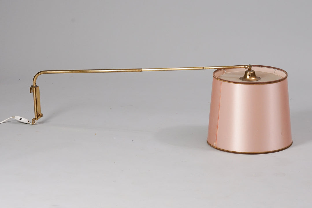 Lamp with a light pink plastic shade. Stem of the lamp is made of brass and is extendable.