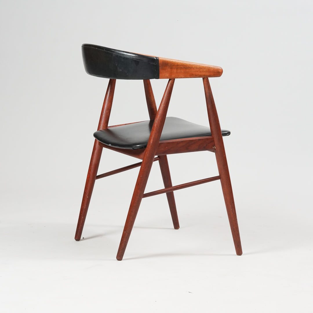 A chair made of teak with faux leather seat and thin backrest.