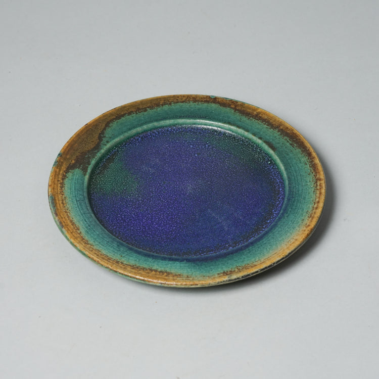 Unique plate with four different colors, blue, green, yellow and red. The colors bleed into each other.