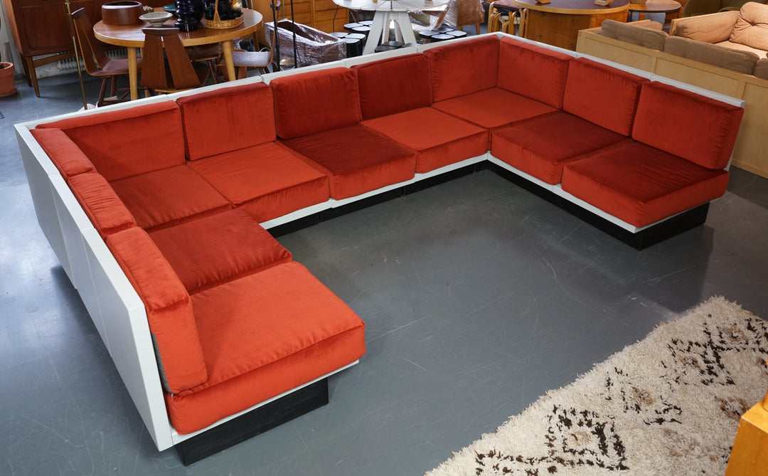 The module couch has white painted frame with black base piece. The cushions are red color.