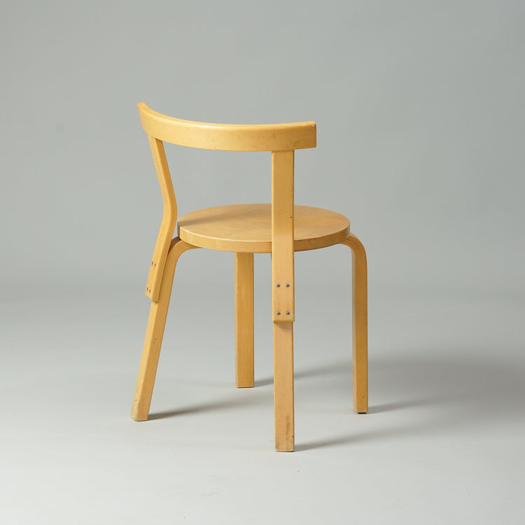Birch chair with four legs, round seat and thin backrest.