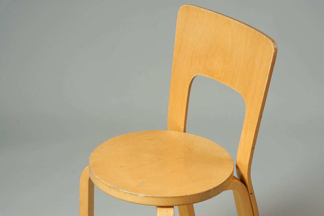 A birch chair with four legs, a backrest and round seat.