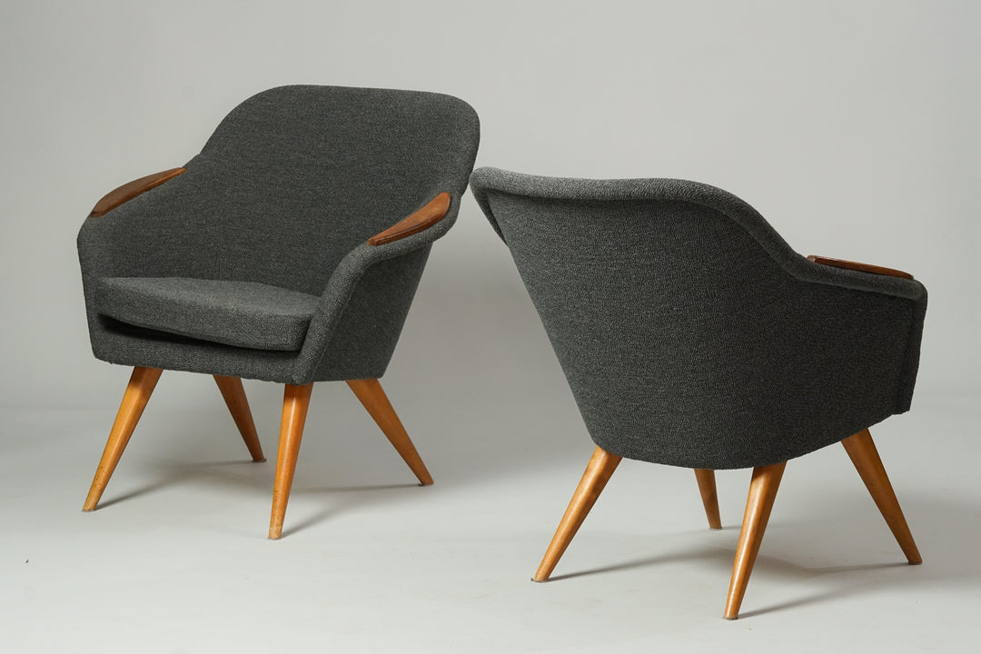 Two similar chair with birch legs and teak armrests. The armchairs are upholstered in grey fabric.