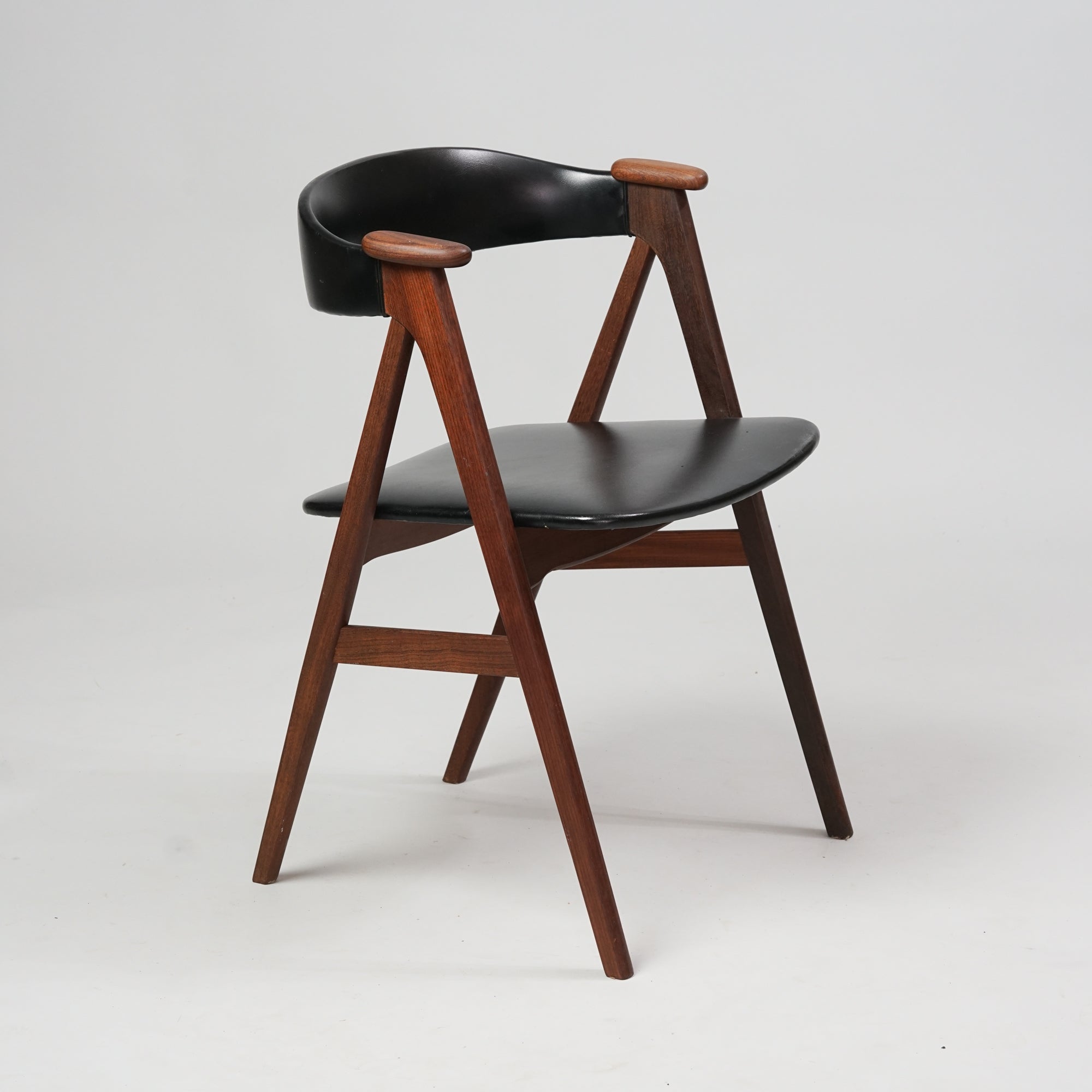 Tiikistä tehty tuoli, jossa keinonahkainen istuin ja selkänoja.