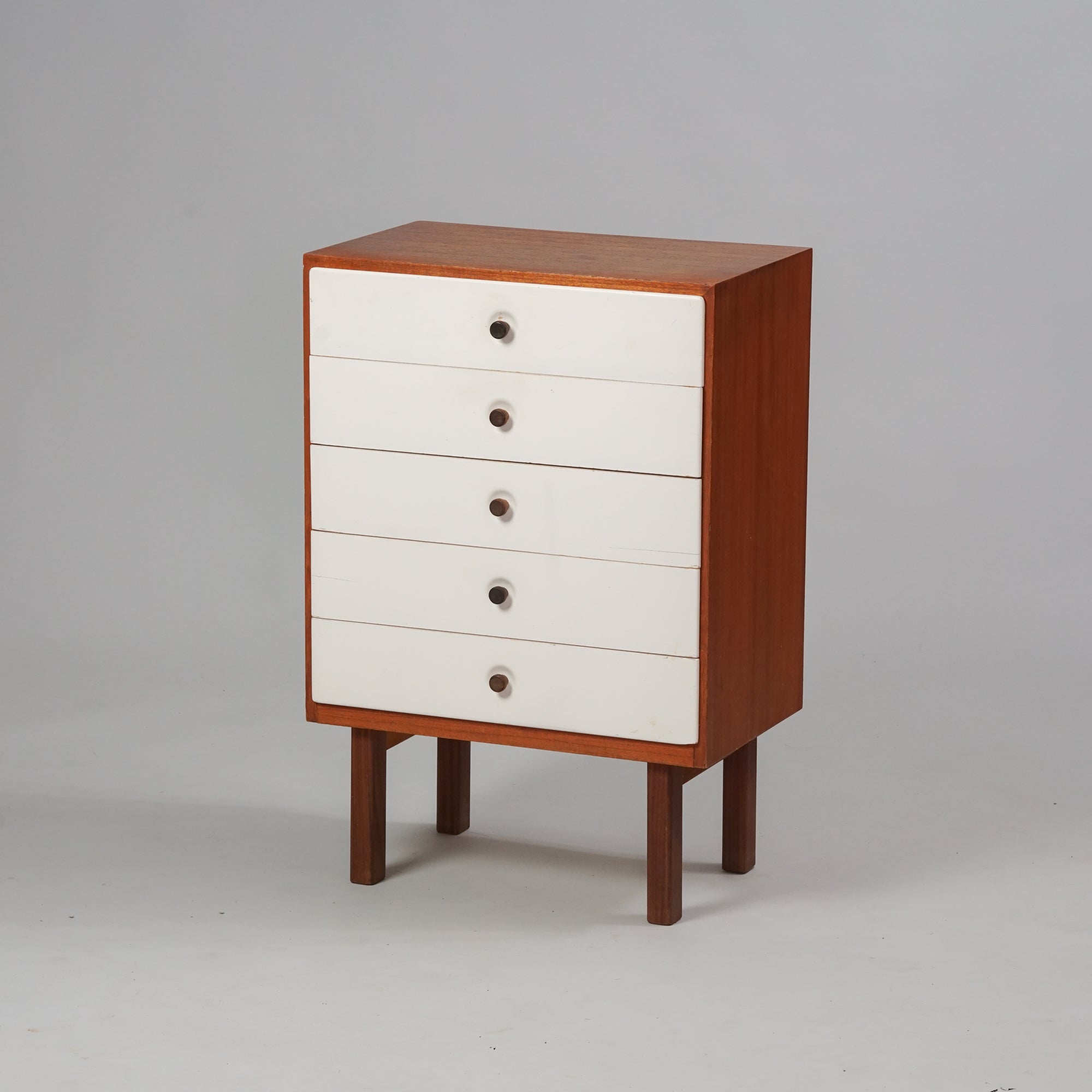 Teak cabinet with five drawers painted white.