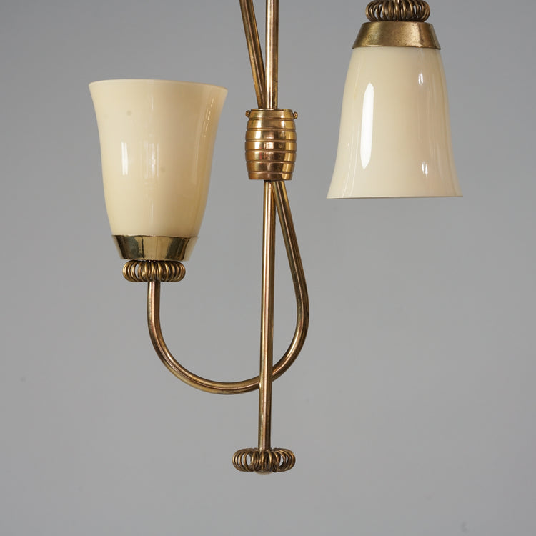 Brass frame lamp, with two opal glass domes. One of the domes is pointed down, the other up.