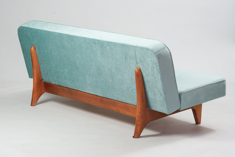 Convertible sofa, with a stained birch frame. The sofa has light blue plush fabric.