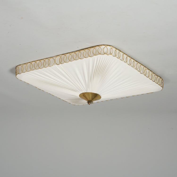 White square plafond where shade is made of pleated fabric. The plafond has brass detailing in middle and on the sides.