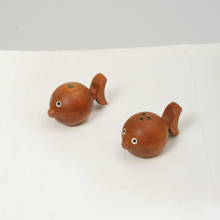 Two teak fish figurines that work as salt and pepper shakers.