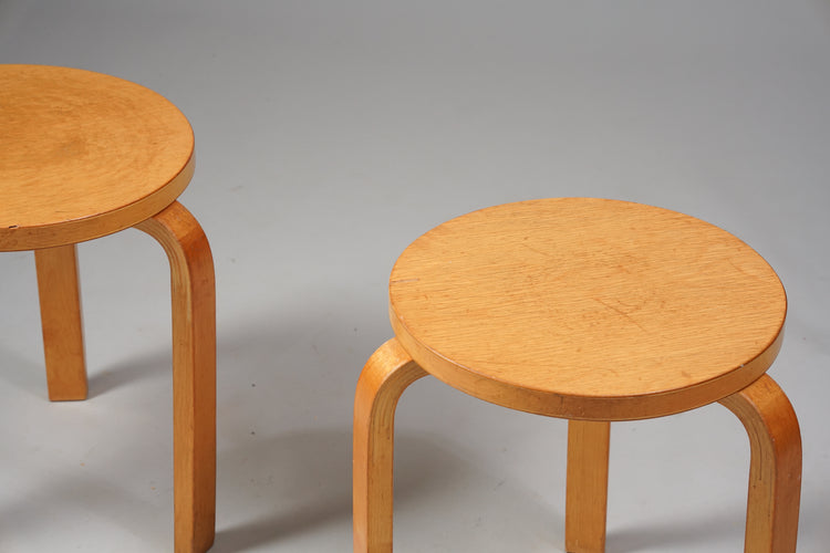 A stool with three legs and a round seat made of birch. 