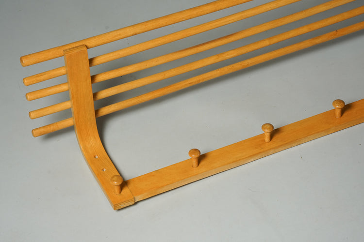 A birch coat rack with a shelf and six wooden hooks. 