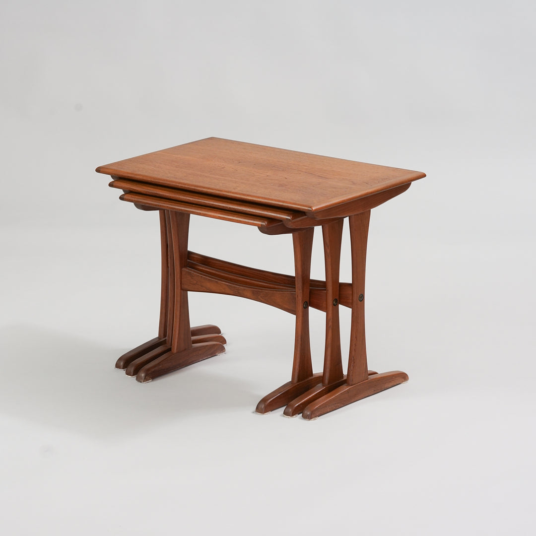 Three similar teak tables in different sizes. The tables fit under each other. 