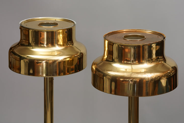 Two identical lamps. Made of brass with the grid inside the shade being plastic.