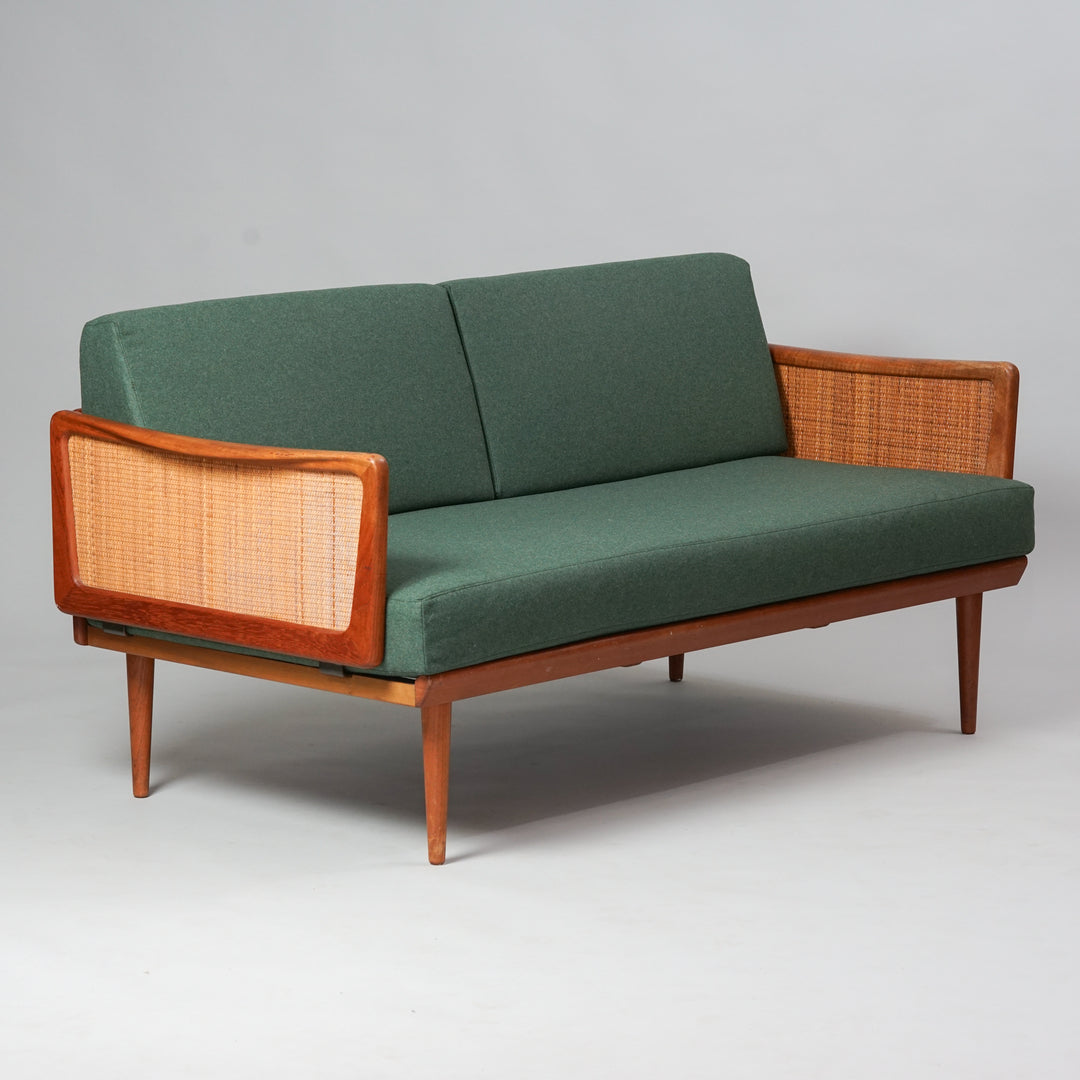 Teak frame sofa, with rattan braiding on the armrests. Upholstered in green fabric.