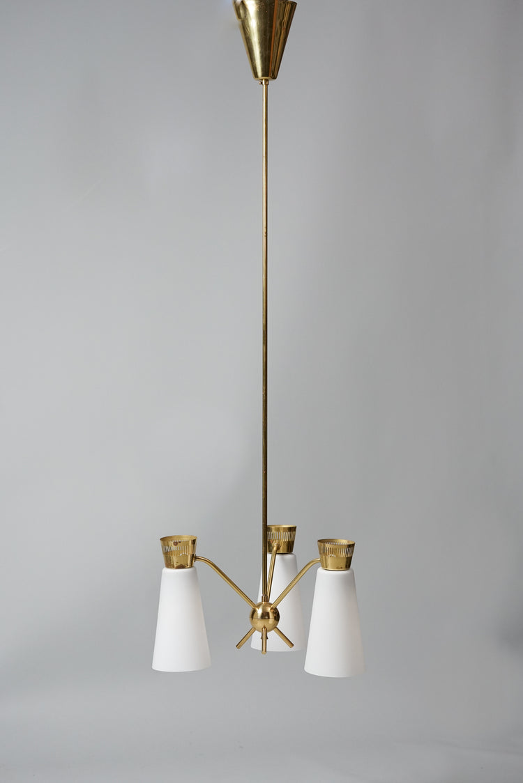 A lamp with three lights, held together by an unique ball decoration in the middle. The base is made of brass and the lamp domes of cloudy white glass.