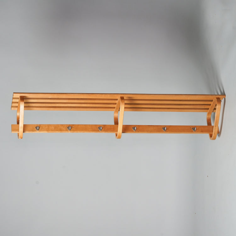 Hatrack made from birch that has three triangle -shaped brackets that mount the rack to the wall. Metal hooks.