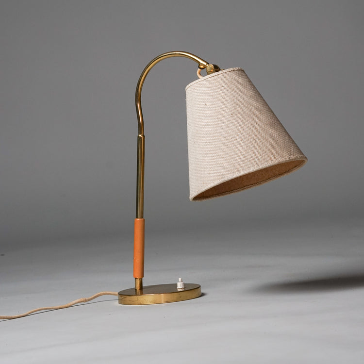 Brass table lamp, with part of the frame in wood. Lampshade is cream-coloured fabric.